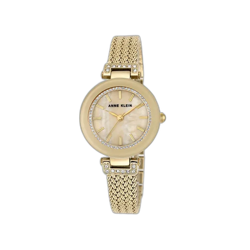 Wyjątkowo elegancki zegarek Anne Klein, łączący złotą bransoletę o plecionej fakturze z subtelną tarczą w kolorze perłowym. Obramowanie tarczy zdobione kryształkami dodaje mu blasku i luksusowego charakteru. Idealny dodatek na wyjątkowe okazje i codzienne stylizacje, podkreślający kobiecy styl.