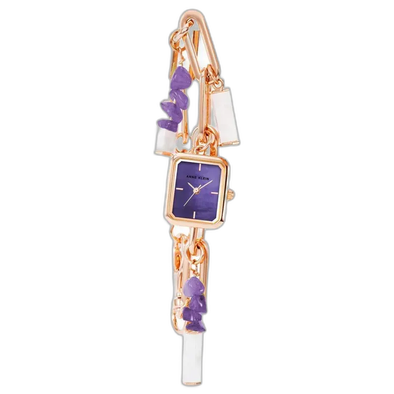 Model ANNE KLEIN CLASSIC 18MM AK-4108AMCH to niezwykle stylowy zegarek, który wyróżnia się artystycznym designem. Koperta o wymiarach 18 mm wykonana w odcieniu różowego złota idealnie współgra z fioletową tarczą, nadając zegarkowi wyrafinowanego charakteru. Zdobienia w formie kamieni i zawieszek dodają mu unikalnego wyglądu, przypominając bardziej bransoletkę niż tradycyjny zegarek. Idealny wybór dla osób poszukujących elegancji z nutą oryginalności.