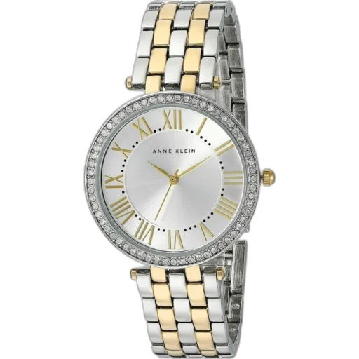 Model ANNE KLEIN 34MM AK-2231SVTT to doskonałe połączenie klasy i nowoczesności. Zegarek posiada elegancką tarczę w srebrnym kolorze, ozdobioną złotymi rzymskimi indeksami, które nadają mu ponadczasowego charakteru. Koperta i bransoleta w dwukolorowym odcieniu (złoto-srebrny) wykonane są z wysokiej jakości materiałów, zapewniając trwałość i wygodę. Ozdobny pierścień wokół tarczy, zdobiony cyrkoniami, podkreśla jego luksusowy wygląd. To idealny wybór dla kobiet, które poszukują eleganckiego dodatku zarówno na co dzień, jak i na wyjątkowe okazje.